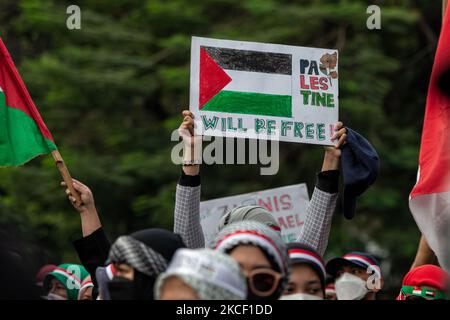 Un indonésien tient une affiche dans le livre « la Palestine sera libre » lors d’une manifestation anti-israélienne à Djakarta sur 21 mai 2021. Des centaines de manifestants ont organisé un rassemblement devant l'ambassade des États-Unis à Jakarta en solidarité avec le peuple palestinien à la suite de violents affrontements entre les forces de sécurité israéliennes et les Palestiniens, exhortant Israël à mettre fin aux attaques sur Gaza, dans lesquelles des femmes et des enfants ont également été tués. (Photo par Afriadi Hikmal/NurPhoto) Banque D'Images