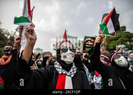 L'indonésien détient des drapeaux nationaux palestiniens lors d'une manifestation contre Israël à Djakarta sur 21 mai 2021. Des centaines de manifestants ont organisé un rassemblement devant l'ambassade des États-Unis à Jakarta en solidarité avec le peuple palestinien à la suite de violents affrontements entre les forces de sécurité israéliennes et les Palestiniens, exhortant Israël à mettre fin aux attaques sur Gaza, dans lesquelles des femmes et des enfants ont également été tués. (Photo par Afriadi Hikmal/NurPhoto) Banque D'Images