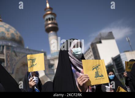 Des femmes voilées détiennent les drapeaux du Hezbollah libanais lors d’un rassemblement en faveur du peuple palestinien sur la place palestinienne dans le centre de Téhéran, sur 22 mai 2021. Un groupe d'hommes et de femmes iraniens se sont réunis sur la place palestinienne pour célébrer la victoire des Palestiniens sur Israël, selon la déclaration lue par un manifestant. (Photo de Morteza Nikoubazl/NurPhoto) Banque D'Images