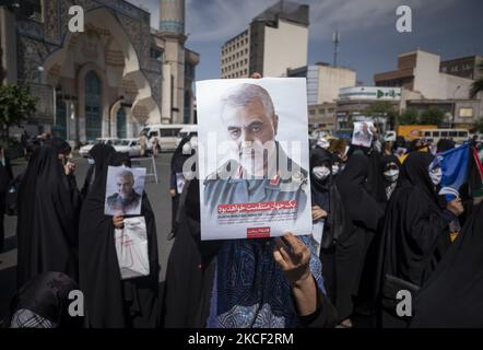 Une iranienne voilée tient un portrait de l'ancien corps des Gardiens de la révolution islamique (IRGC), le général Qasem Soleimani, qui a été tué lors d'une attaque par drone américain à l'aéroport de Bagdad, lors d'un rassemblement sur la place palestinienne dans le centre de Téhéran, sur 22 mai 2021. Un groupe d'hommes et de femmes iraniens se sont réunis sur la place palestinienne pour célébrer la victoire des Palestiniens sur Israël, selon la déclaration lue par un manifestant. (Photo de Morteza Nikoubazl/NurPhoto) Banque D'Images