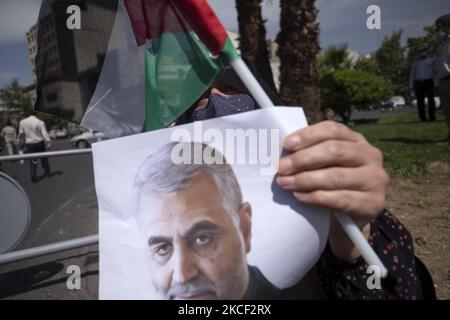 Une femme iranienne voilée détient un drapeau palestinien et un portrait de l'ancien corps des Gardiens de la révolution islamique (IRGC), le général Qasem Soleimani, Qui a été tué lors d'une attaque par drone américain à l'aéroport de Bagdad, tout en assistant à un rassemblement en faveur du peuple palestinien, sur la place palestinienne dans le centre de Téhéran, sur 22 mai 2021. Un groupe d'hommes et de femmes iraniens se sont réunis sur la place palestinienne pour célébrer la victoire des Palestiniens sur Israël, selon la déclaration lue par un manifestant. (Photo de Morteza Nikoubazl/NurPhoto) Banque D'Images