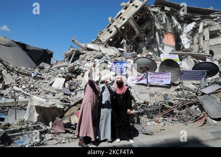 Les femmes palestiniennes posent pour une photo de "selfie" devant un bâtiment démoli dans le quartier commercial d'Al-Remal dans la ville de Gaza, récemment visé par des frappes aériennes israéliennes sur 23 mai 2021. - Les Gazaouis ont commencé à piecer leur vie après un conflit dévastateur avec Israël qui a tué plus de 200 personnes et fait des milliers de sans-abri dans l'enclave palestinienne appauvrie, des jours après qu'un cessez-le-feu négocié par l'Égypte ait mis fin à des frappes aériennes israéliennes mortelles et en a fait des tirs de roquettes vers Israël. (Photo de Majdi Fathi/NurPhoto) Banque D'Images