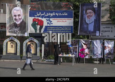 Une iranienne passe devant un portrait de l'ancien corps des Gardiens de la révolution islamique (IRGC), le général Qasem Soleimani (L), Qui a tué lors d’une attaque par drone américain à l’aéroport de Bagdad, un panneau d’affichage anti-israélien et un portrait du chef libanais du Hezbollah Hassan Nasrallah lors d’un rassemblement anti-guerre en faveur d’enfants palestiniens, dans le centre de Téhéran, sur 24 mai 2021. (Photo de Morteza Nikoubazl/NurPhoto) Banque D'Images