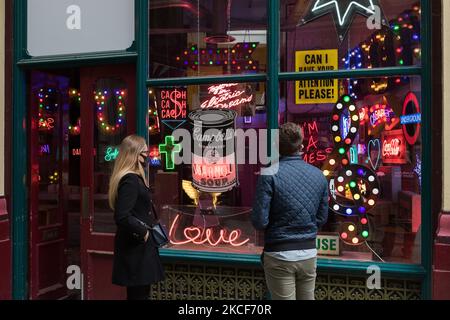 LONDRES, ROYAUME-UNI - 25 MAI 2021 : les visiteurs regardent une installation avec des panneaux et des néons de films hollywoodiens créés par feu Chris Bracey de Gods Own Junkyard lors d'un appel photo pour l'exposition « Electric City » au Leadenhall Market, sur 25 mai 2021 à Londres, en Angleterre. Dieux Own Junkyard's and Leadenhall Market 'Electric City' (26th mai – samedi 31st juillet 2021) est une exposition immersive de néons et de pièces de table faites pour le film, y compris des éléments de signalisation de Stanley Kubrick's Wide Shut, Judge Dredd, Batman, Tomb Raider, Charlie et The Chocolate Factory et Th Banque D'Images