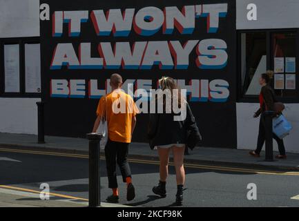 Les gens marchent à côté d'une fresque avec les mots "IL ne sera PAS TOUJOURS COMME ÇA", par l'artiste irlandais Emmalene Blake/ESTR, vu dans le centre de Dublin. Le mercredi 26 mai 2021, à Dublin, Irlande. (Photo par Artur Widak/NurPhoto) Banque D'Images