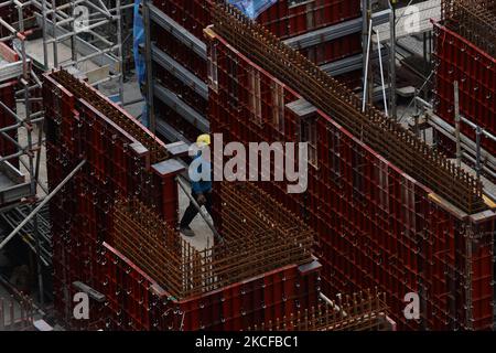 Un travailleur migrant travaille sur un chantier de construction à 29 mai 2021, à Singapour. Singapour entre un mois d'alerte accrue de 16 mai à 13 juin pour freiner la propagation des cas de COVID-19 dans la communauté locale. De nouvelles restrictions sur les mouvements et les activités ont été introduites, telles que la limitation de l'interaction sociale à deux, l'interdiction de manger dehors et une capacité d'exploitation réduite dans les centres commerciaux, les bureaux et les attractions. Au 17 mai, les intervenants de l'industrie de la construction ont appelé le groupe de travail multiministériel à faire venir les travailleurs étrangers de façon sécuritaire et contrôlée après la construction de l'environnement Banque D'Images