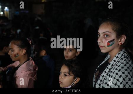 Des enfants palestiniens détiennent le drapeau palestinien lors d'un rassemblement au milieu des ruines de maisons détruites par des frappes israéliennes, dans la ville de Gaza, sur 30 mai 2021. (Photo de Majdi Fathi/NurPhoto) Banque D'Images