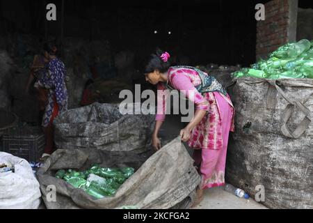 Les femmes qui travaillent passent par des bouteilles en polyéthylène téréphtalate (PET) dans une usine de recyclage à Dhaka, au Bangladesh, sur le 02 juin 2021. Le recyclage des bouteilles en plastique est devenu une activité en pleine croissance au cours des deux dernières années et contribue à protéger l'environnement. Selon la Bangladesh PET Flakes Manufacturers and Exportateurs Association (BPFMEA), le Bangladesh exporte en moyenne près de 30 000 tonnes de flocons de bouteilles en PET, principalement vers la Chine, la Corée du Sud et Taïwan, pour une valeur de $14 millions de dollars par an. (Photo de Kazi Salahuddin Razu/NurPhoto) Banque D'Images