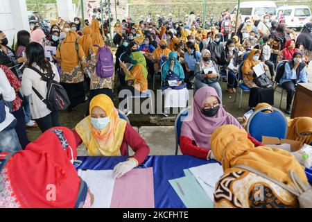 Les résidents ont la queue pour obtenir une dose du vaccin Covid-19 de Sinovac Biotech Ltd. Pendant la vaccination de masse à Salatiga sur 3 juin 2021. Le ministère indonésien de la Santé vise une augmentation du programme de vaccination, qui passe de 500 000 doses par jour à 1 millions de doses par jour. (Photo par Galih Yoga/NurPhoto) Banque D'Images