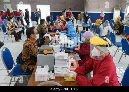 Les résidents ont la queue pour obtenir une dose du vaccin Covid-19 de Sinovac Biotech Ltd. Pendant la vaccination de masse à Salatiga sur 3 juin 2021. Le ministère indonésien de la Santé vise une augmentation du programme de vaccination, qui passe de 500 000 doses par jour à 1 millions de doses par jour. (Photo par Galih Yoga/NurPhoto) Banque D'Images