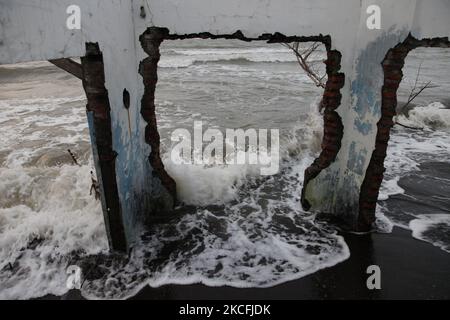 Les vagues frappent une maison abandonnée dans le village de la côte nord de la ville de Pekalonga, au centre de Java, sur 3 juin 2021. Sur la base des données de l'Agence géologique du Ministère indonésien de l'énergie et des ressources minérales, la ville de Pekalonga connaît une affaissement des terres de 6 centimètres par an, causée par l'utilisation massive des eaux souterraines par les housolds, l'agriculture, l'industrie et le changement climatique mondial, ce qui, si ce n'est immédiatement atténué, que la ville devrait couler en 2036. (Photo par Aditya Irawan/NurPhoto) Banque D'Images