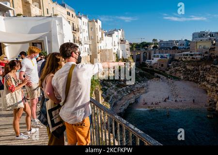 Les gens donnent sur le balcon donnant sur la falaise lama Monachile à Polignano a Mare sur 4 juin 2021. Puglia est la plus belle région du monde pour la deuxième fois consécutive, le prix « meilleure destination de voyage au monde » reconnu par National Geographic, et également confirmé par Lonely Planet et New York Times. Les touristes commencent à affluer les plages et les endroits les plus caractéristiques de la région comme Polignano a Mare, la plupart du temps des touristes étrangers mais aussi des Apuliens eux-mêmes qui préfèrent profiter de la mer surtout les week-ends. (Photo par Davide Pischettola/N. Banque D'Images