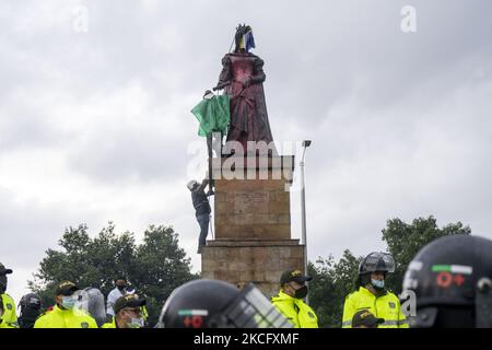 Misak se dresse devant des policiers alors qu'elle proteste à côté de la statue de la reine Isabel d'Espagne sur 09 juin 2021 à Bogota, en Colombie. Une autre journée de manifestations à Bogota, en Colombie, aujourd'hui en compagnie de Misak indigène qui prétendait faire tomber la statue de ''Isabel le catholique'' et le conquérant Cristobal Colon d'Amérique. (Photo de David Rodriguez/NurPhoto) Banque D'Images