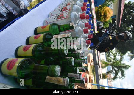 Les agents détruisent les boissons alcoolisées confisquées pour ne pas utiliser les timbres d'accise conformément aux règlements du Bureau de surveillance et de service des douanes (KPPBC) TMP C Pantoloan à Palu, province centrale de Sulawesi, Indonésie, le 10 juin 2021. Les agents des douanes et de l'accise ont arrêté, confisqué et détruit des milliers de bouteilles de boissons alcoolisées et de cigarettes illégales parce qu'elles ont nui aux finances du pays. (Photo par Mohamad Hamzah/NurPhoto) Banque D'Images