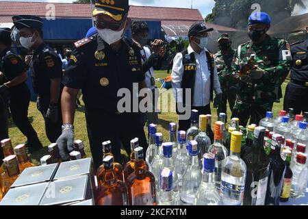 Les agents détruisent les boissons alcoolisées confisquées pour ne pas utiliser les timbres d'accise conformément aux règlements du Bureau de surveillance et de service des douanes (KPPBC) TMP C Pantoloan à Palu, province centrale de Sulawesi, Indonésie, le 10 juin 2021. Les agents des douanes et de l'accise ont arrêté, confisqué et détruit des milliers de bouteilles de boissons alcoolisées et de cigarettes illégales parce qu'elles ont nui aux finances du pays. (Photo par Mohamad Hamzah/NurPhoto) Banque D'Images