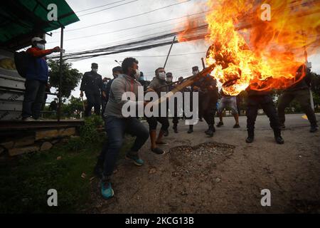 Le personnel de police tente d'éveiller une effigie du Premier ministre du Népal, KP Sharma Oli, incendiée par l'alliance de l'opposition lors d'une manifestation contre le mouvement inconstitutionnel du gouvernement, notamment la dissolution de la Chambre des représentants et des élections anticipées dans le cadre du confinement de la pandémie du coronavirus à Katmandou, au Népal samedi, 12 juin, 2021. (Photo par Saroj Baizu/NurPhoto) Banque D'Images