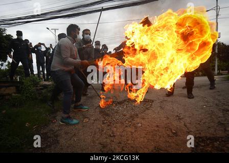 Le personnel de police tente d'éveiller une effigie du Premier ministre du Népal, KP Sharma Oli, incendiée par l'alliance de l'opposition lors d'une manifestation contre le mouvement inconstitutionnel du gouvernement, notamment la dissolution de la Chambre des représentants et des élections anticipées dans le cadre du confinement de la pandémie du coronavirus à Katmandou, au Népal samedi, 12 juin, 2021. (Photo par Saroj Baizu/NurPhoto) Banque D'Images