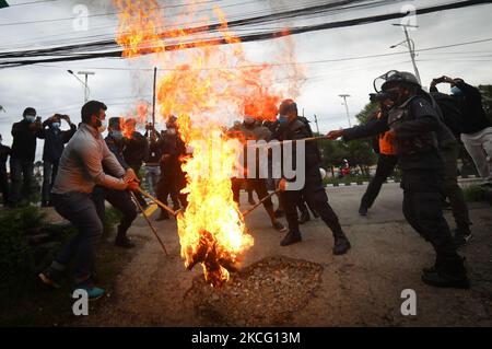 Le personnel de police tente d'éveiller une effigie du Premier ministre du Népal, KP Sharma Oli, incendiée par l'alliance de l'opposition lors d'une manifestation contre le mouvement inconstitutionnel du gouvernement, notamment la dissolution de la Chambre des représentants et des élections anticipées dans le cadre du confinement de la pandémie du coronavirus à Katmandou, au Népal samedi, 12 juin, 2021. (Photo par Saroj Baizu/NurPhoto) Banque D'Images