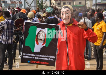 Un manifestant portant une bannière portant un masque lors d'une manifestation civile dans le parc Gani Fahweyinmi, district Ojota de Lagos, au Nigeria, lieu de la manifestation de 12 juin, le 12 juin 2021.la police nigériane sur 12 juin 2021 a tiré du gaz lacrymogène pour disperser les manifestants antigouvernementaux à Lagos et dans la capitale, Abuja, en arrêtant de nombreuses personnes alors que d'autres ont été blessées. De nombreux activistes ont appelé samedi à des manifestations nationales à l'occasion de la Journée de la démocratie de 12 juin, qui marque le passage du Nigeria à un régime civil il y a plus de 20 ans, sur ce qu'ils critiquent comme une mauvaise gouvernance et une insécurité, ainsi que sur la récente interdiction du « Twitter » par le c Banque D'Images