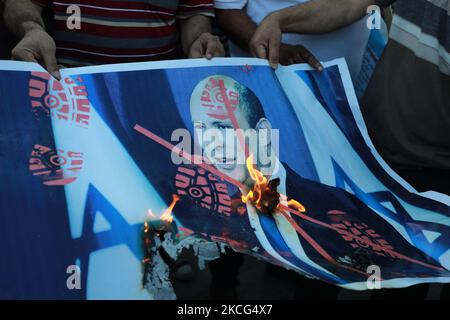 Les Palestiniens brûlent une affiche représentant le Premier ministre israélien Naftali Bennett lors d'une manifestation au sujet d'une procession d'un drapeau ordonnant des groupes israéliens d'extrême-droite dans la vieille ville de Jérusalem-est et autour de celle-ci, à Khan Younis, dans le sud de la bande de Gaza 15 juin 2021. (Photo de Majdi Fathi/NurPhoto) Banque D'Images