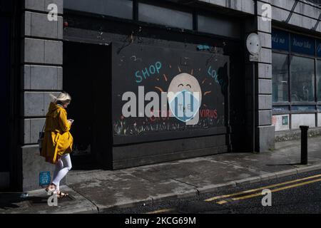 Une fresque peinte sur un front de magasin embarqué lit 'hop local - Stop the virus' à Dublin, Irlande, sur 25 juillet 2020. (Photo de Graham Martin/NurPhoto) Banque D'Images