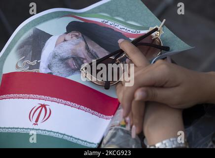 Une femme partisane du président iranien élu, Ebrahim Raisi, détient une affiche électorale de Raisi et un drapeau de l’Iran, tout en assistant à un rassemblement pour célébrer la victoire de Raisi aux élections présidentielles de 18 juin en Iran, dans le sud de Téhéran sur 19 juin 2021. Raisi a remporté les élections présidentielles iraniennes et a élu le nouveau président iranien. (Photo de Morteza Nikoubazl/NurPhoto) Banque D'Images