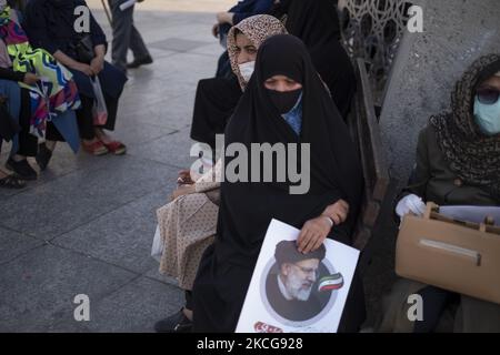 Une femme partisane du président iranien élu Ebrahim Raisi tient une affiche électorale de Raisi tout en assistant à un rassemblement pour célébrer la victoire de Raisi aux élections présidentielles de 18 juin en Iran, dans le sud de Téhéran sur 19 juin 2021. Raisi a remporté les élections présidentielles iraniennes et a élu le nouveau président iranien. (Photo de Morteza Nikoubazl/NurPhoto) Banque D'Images