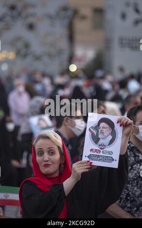 Une femme partisane du président iranien élu Ebrahim Raisi tient une affiche électorale de Raisi tout en assistant à un rassemblement pour célébrer la victoire de Raisi aux élections présidentielles de 18 juin en Iran, dans le sud de Téhéran sur 19 juin 2021. Raisi a remporté les élections présidentielles iraniennes et a élu le nouveau président iranien. (Photo de Morteza Nikoubazl/NurPhoto) Banque D'Images