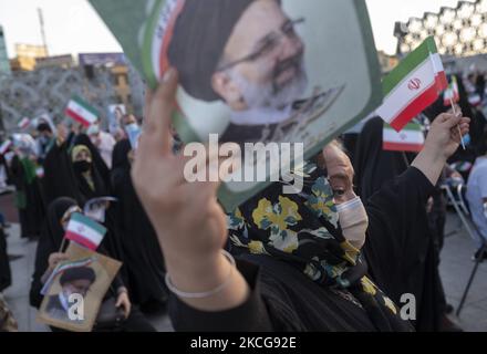 Une femme partisane du président iranien, Ebrahim Raisi, tient une affiche électorale de Raisi et un drapeau iranien lors d’un rassemblement pour célébrer la victoire de Raisi aux élections présidentielles de 18 juin en Iran, dans le sud de Téhéran sur 19 juin 2021. Raisi a remporté les élections présidentielles iraniennes et a élu le nouveau président iranien. (Photo de Morteza Nikoubazl/NurPhoto) Banque D'Images