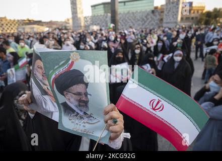 Une femme partisane du président iranien, Ebrahim Raisi, présente les affiches électorales de Raisi et un drapeau iranien lors d’un rassemblement pour célébrer la victoire de Raisi aux élections présidentielles de 18 juin en Iran, dans le sud de Téhéran sur 19 juin 2021. Raisi a remporté les élections présidentielles iraniennes et a élu le nouveau président iranien. (Photo de Morteza Nikoubazl/NurPhoto) Banque D'Images