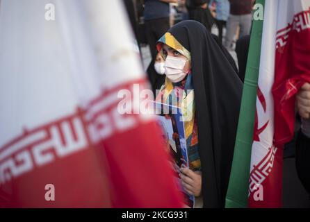 Une femme partisane du président iranien élu, Ebrahim Raisi, se présente à côté des drapeaux iraniens tout en assistant à un rassemblement pour célébrer la victoire de Raisi aux élections présidentielles de 18 juin en Iran, dans le sud de Téhéran sur 19 juin 2021. Raisi a remporté les élections présidentielles iraniennes et a élu le nouveau président iranien. (Photo de Morteza Nikoubazl/NurPhoto) Banque D'Images