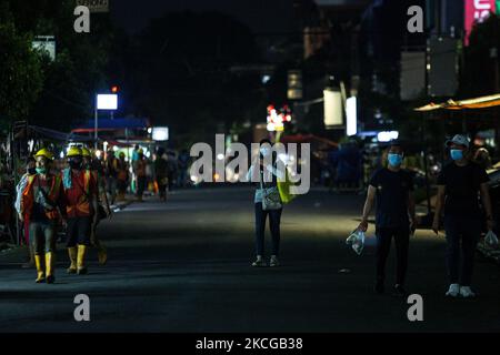 On voit des gens marcher sur la rue généralement occupée de Sabang Street pendant la fermeture d'un centre de nourriture de rue populaire parmi les locaux et les touristes, en raison des préoccupations de l'épidémie de coronavirus à Jakarta le 21 juin, 2021. Les administrations de Jakarta ont resserré les restrictions en fermant les routes et en ordonnant aux magasins et aux restaurants de fermer leurs portes plus tôt dans le cadre d'une tentative de freiner la propagation du coronavirus. Les autorités sanitaires indonésiennes ont annoncé lundi le plus grand bond d'une journée dans le nombre de nouveaux cas d'infection à coronavirus, le nombre de cas confirmés depuis le début de la pandémie ayant dépassé 2 millions. La poussée est de mettre des sous-coups Banque D'Images