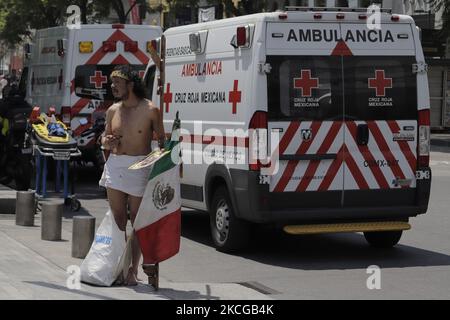 Une personne habillée comme Jésus-Christ a un drapeau mexicain et une croix devant les ambulances pendant le premier simulacrum national 2021 sur l'Avenida Juárez, Mexico. Au cours du simulacre, des services d'urgence comme les pompiers, la police, la Croix-Rouge et le personnel du Secrétariat de la gestion intégrale des risques et de la protection civile de la capitale ont été déployés en cas de séisme de 8,1 Richter avec un épicentre à Guerrero, avec une perception très forte. (Photo de Gerardo Vieyra/NurPhoto) Banque D'Images