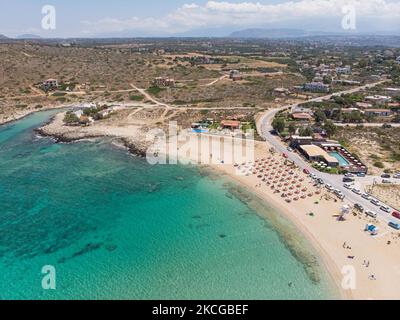 Tourisme en Grèce - Images aériennes panoramiques capturées à partir d'un drone de la plage de Stavros, située à Akrotiri près de la Canée. La plage est devenue très populaire en 70s car elle a présenté des scènes du film Zorba le grec avec Anthony Quinn. Les gens apprécient l'ombre du parasol et du transat d'un bar de plage, mais aussi d'autres ont posé leur serviette et se détendre pendant leurs vacances. La plage forme un petit port naturel à pied de la très raide montagne Vardies, où les rochers se submergent dans le cristal transparent turquoise exotique eau méditerranéenne de la plage. Les touristes aiment nager Banque D'Images