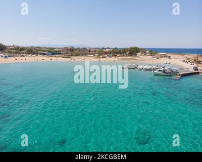 Tourisme en Grèce - Images aériennes panoramiques capturées à partir d'un drone de la plage de Stavros, située à Akrotiri près de la Canée. La plage est devenue très populaire en 70s car elle a présenté des scènes du film Zorba le grec avec Anthony Quinn. Les gens apprécient l'ombre du parasol et du transat d'un bar de plage, mais aussi d'autres ont posé leur serviette et se détendre pendant leurs vacances. La plage forme un petit port naturel à pied de la très raide montagne Vardies, où les rochers se submergent dans le cristal transparent turquoise exotique eau méditerranéenne de la plage. Les touristes aiment nager Banque D'Images