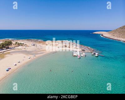 Tourisme en Grèce - Images aériennes panoramiques capturées à partir d'un drone de la plage de Stavros, située à Akrotiri près de la Canée. La plage est devenue très populaire en 70s car elle a présenté des scènes du film Zorba le grec avec Anthony Quinn. Les gens apprécient l'ombre du parasol et du transat d'un bar de plage, mais aussi d'autres ont posé leur serviette et se détendre pendant leurs vacances. La plage forme un petit port naturel à pied de la très raide montagne Vardies, où les rochers se submergent dans le cristal transparent turquoise exotique eau méditerranéenne de la plage. Les touristes aiment nager Banque D'Images