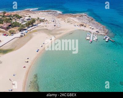 Tourisme en Grèce - Images aériennes panoramiques capturées à partir d'un drone de la plage de Stavros, située à Akrotiri près de la Canée. La plage est devenue très populaire en 70s car elle a présenté des scènes du film Zorba le grec avec Anthony Quinn. Les gens apprécient l'ombre du parasol et du transat d'un bar de plage, mais aussi d'autres ont posé leur serviette et se détendre pendant leurs vacances. La plage forme un petit port naturel à pied de la très raide montagne Vardies, où les rochers se submergent dans le cristal transparent turquoise exotique eau méditerranéenne de la plage. Les touristes aiment nager Banque D'Images