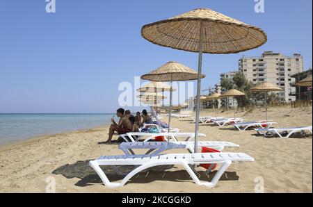 Les touristes se détendent sur une plage clôturée par l'armée turque depuis 1974 dans la zone côtière abandonnée de Varosha, une banlieue de la ville de Famagusta dans le nord de Chypre contrôlée par la Turquie. Samedi, 26 juin 2021. (Photo de Danil Shamkin/NurPhoto) Banque D'Images