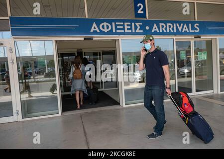 Passagers avec masque de visage comme vu à l'aéroport international de Chania CHQ dans l'île grecque de Crète. La Crète est une destination de voyage populaire avec des plages célèbres et une industrie touristique fortement développée, avec une longue saison touristique car elle est située dans le sud de la Grèce dans les eaux méditerranéennes. La Grèce tente de stimuler son tourisme et de donner des privilèges à se faire vacciner contre la pandémie du coronavirus Covid-19, les touristes internationaux et les locaux, car le pays dépend largement de l'industrie touristique. Le nombre de passagers de l'aviation mondiale a diminué en raison des restrictions de voyage, des mesures de sécurité su Banque D'Images