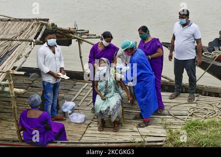 Une vieille femme prend la vaccination Covishield sur un bateau sur la rive de la rivière Mundeshwari, village de Chitnan, Inde, 29 juin, 2021. Selon un rapport des médias indiens, Cipla cherche à importer le vaccin Moderna COVID-19 en Inde. (Photo par Indranil Aditya/NurPhoto) Banque D'Images