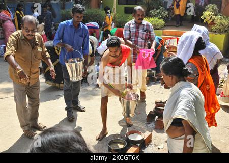 Le prêtre hindou sauve de l'eau sainte pour bénir le pongala lors du festival Attukal Pongala Mahotsavam dans la ville de Thiruvananthapuram (Trivandrum), Kerala, en Inde, sur 19 février 2019. Le festival Attukal Pongala Mahotsavam est célébré chaque année par des millions de femmes hindoues. Au cours de ce festival, les femmes préparent le Pongala (riz cuit avec des jaggery, ghee, noix de coco ainsi que d'autres ingrédients) à l'ouverture dans de petits pots pour plaire à la déesse Attukal Devi (populairement connu sous le nom d'Attukal Amma). Pongala (qui signifie littéralement bouillir plus) est une offrande ritualiste d'un plat sucré, composé de porridg de riz Banque D'Images