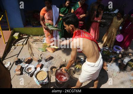 Le prêtre hindou sauve de l'eau sainte pour bénir le pongala lors du festival Attukal Pongala Mahotsavam dans la ville de Thiruvananthapuram (Trivandrum), Kerala, en Inde, sur 19 février 2019. Le festival Attukal Pongala Mahotsavam est célébré chaque année par des millions de femmes hindoues. Au cours de ce festival, les femmes préparent le Pongala (riz cuit avec des jaggery, ghee, noix de coco ainsi que d'autres ingrédients) à l'ouverture dans de petits pots pour plaire à la déesse Attukal Devi (populairement connu sous le nom d'Attukal Amma). Pongala (qui signifie littéralement bouillir plus) est une offrande ritualiste d'un plat sucré, composé de porridg de riz Banque D'Images