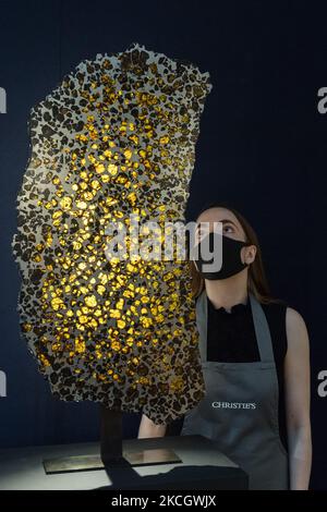 LONDRES, ROYAUME-UNI - 05 JUILLET 2021 : un membre du personnel regarde une portion monolithique de la météorite fukang de la province de Xinjiang, estime de 350 000 à 550 000 £ lors d'un appel photo pour la Classic week à la maison de vente aux enchères Christie, Une série marquise de neuf enchères qui présentent des œuvres d'art de l'antiquité au 20th siècle sur 05 juillet 2021 à Londres, en Angleterre. (Photo de Wiktor Szymanowicz/NurPhoto) Banque D'Images