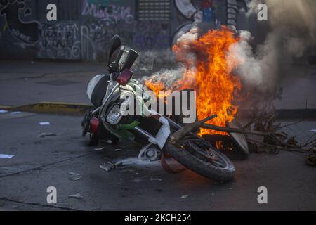 Une moto de police brûle au milieu des funérailles de Luisa Toledo Sepulveda, mère des frères Rafael(18) et Eduardo Vergara Toledo(19). Assassiné par la police des carabineros de Chili, pendant la dictature civilo-militaire d'Augusto Pinochet. Elle a consacré sa vie à lutter pour la justice pour ses enfants. Pour cette raison, elle est populairement considérée comme la mère du peuple qui combat et de tous les jeunes combattants. Sur 7 juillet 2021 dans Villa Francia. Santiago du Chili. (Photo de Claudio Abarca Sandoval/NurPhoto) Banque D'Images