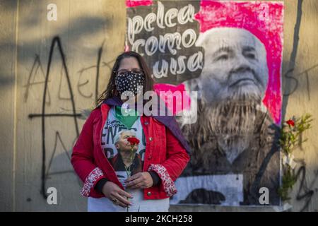 Une personne tient une rose, debout devant une affiche avec l'image de Luisa Toledo au milieu des funérailles de Luisa Toledo Sepulveda, mère des frères Rafael(18) et Eduardo Vergara Toledo(19). Assassiné par la police des carabineros de Chili, pendant la dictature civilo-militaire d'Augusto Pinochet. Elle a consacré sa vie à lutter pour la justice pour ses enfants. Pour cette raison, elle est populairement considérée comme la mère du peuple qui combat et de tous les jeunes combattants. Sur 7 juillet 2021 à Santiago du Chili. (Photo de Claudio Abarca Sandoval/NurPhoto) Banque D'Images