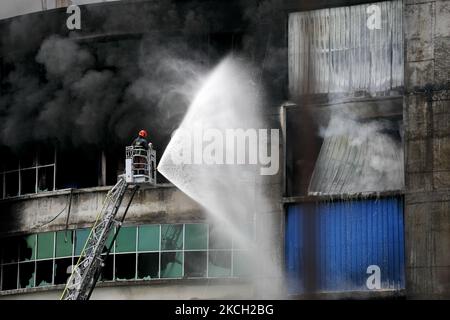 Les pompiers travaillent sur les lieux d'un incendie qui a éclaté dans une usine nommée Hashem Foods Ltd. À Rupganj, dans le district de Narayanganj, à la périphérie de Dhaka, au Bangladesh, en 9 juillet 2021. Au moins 49 corps ont été récupérés dans l'usine alimentaire de six étages de Rupganj, à Naryanganj, ce qui a fait 52 morts. (Photo de Kazi Salahuddin Razu/NurPhoto) Banque D'Images