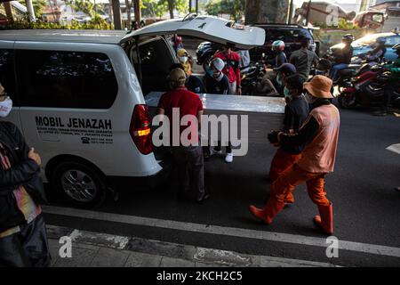 Les fonctionnaires portent un cercueil contenant le corps d'un homme, 66 ans, dans l'ambulance après qu'il a été trouvé mort sur un banc dans le centre-ville, soupçonné d'avoir le coronavirus COVID-19, à Jakarta, sur 9 juillet 2021. L'Indonésie a imposé des restrictions d'urgence en raison de la nouvelle vague de COVID-19 à Java et sur l'île de Bali. Le pays a enregistré plus de 2 400 000 cas de coronavirus (COVID-19) et plus de 64 000 décès depuis le début de la pandémie. (Photo par Afriadi Hikmal/NurPhoto) Banque D'Images