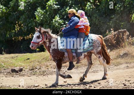 Deux personnes de Rapa Nui à cheval brun et blanc le long d'une route de terre sur l'île de Pâques, au Chili, sur 14 mars 2010. (Photo de Creative Touch Imaging Ltd./NurPhoto) Banque D'Images