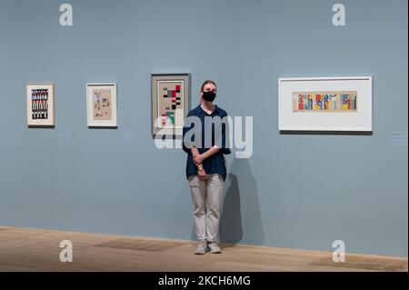 LONDRES, ROYAUME-UNI - 13 JUILLET 2021 : un membre du personnel de la galerie pose avec (L-R) vertical-horizontal composition (1926-1927), esquisse pour Aubette composition (1927), composition pour l'Aubette (1927) et Aubette 198 (conception pour trois murs de la barre Aubette) (1927) par Sophie Taeuber-ARP lors d'un photocall pour promouvoir la nouvelle exposition à Tate Modern sur 13 juillet 2021 à Londres, en Angleterre. L'exposition (15 juillet – 17 octobre 2021) sera la première au Royaume-Uni à présenter les œuvres de Sophie Taeuber-ARP (1889-1943), l'une des plus innovantes artistes et designers de l'avant-garde du 20th siècle, t Banque D'Images