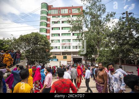 Les travailleurs du secteur des vêtements prêts à l'emploi (RMG) se rassemblent à l'extérieur d'une usine de vêtements à Mohammadpur, Dhaka, sur 13 juillet 2021, car un incendie se produit au troisième étage de l'usine. Environ 5000 travailleurs travaillent dans cette usine. (Photo d'Ahmed Salahuddin/NurPhoto) Banque D'Images